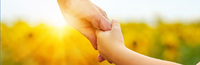 An adult and child holding hands
